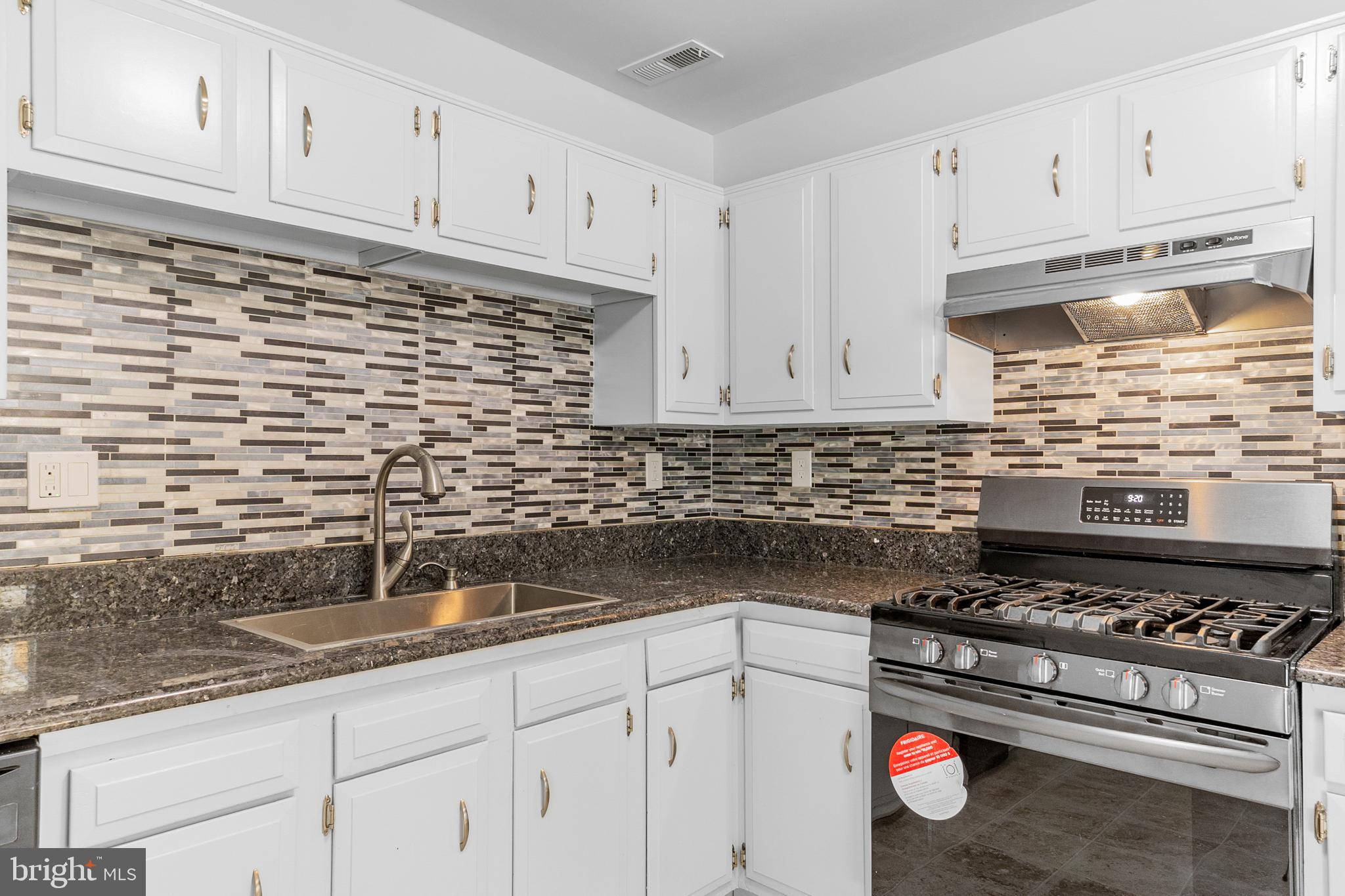 31 Phoenix Court Sewell, NJ 08080 - Photo 9 of 24 a kitchen with granite countertop a stove sink and cabinets