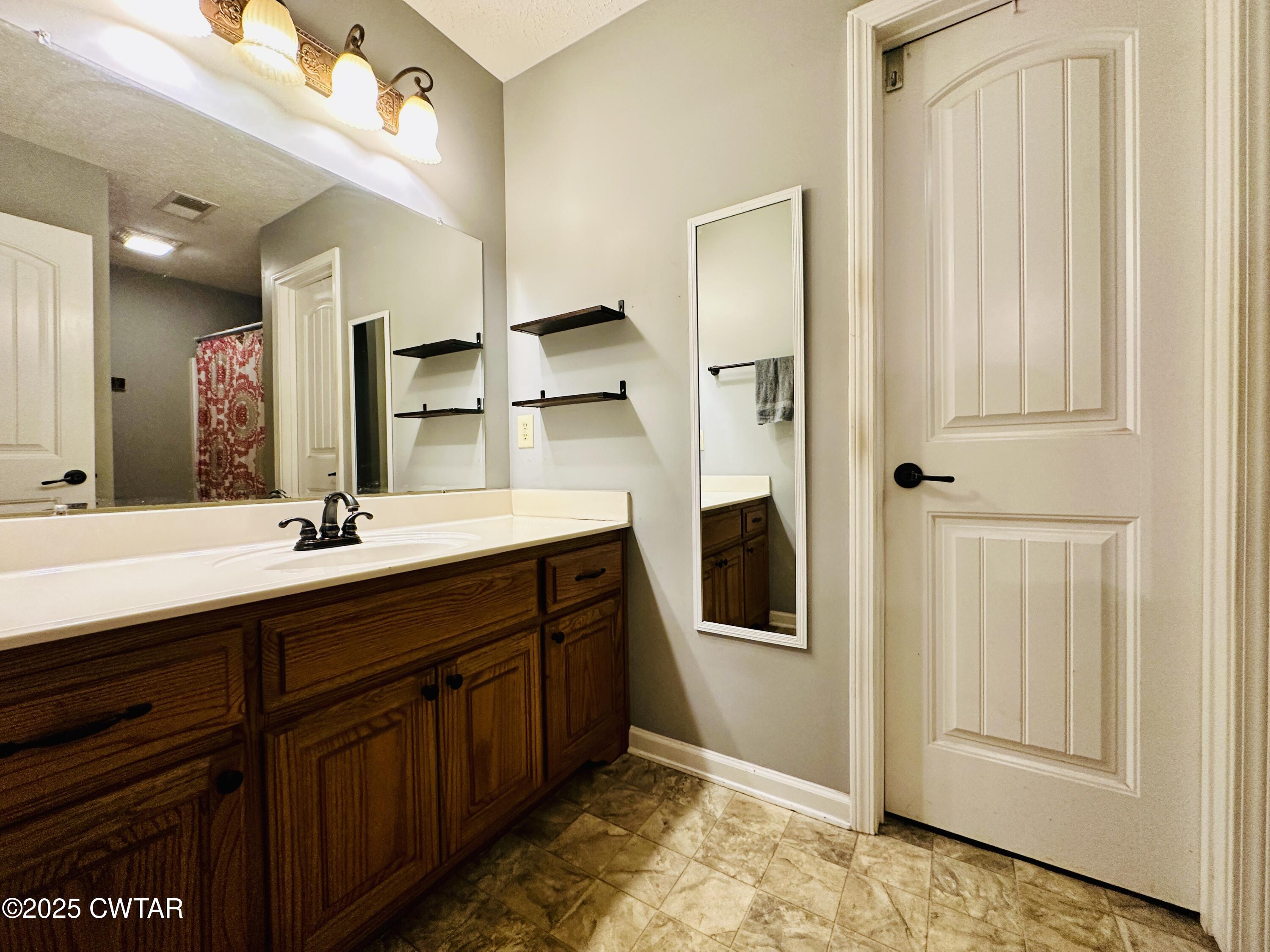 75 Bray Lane Beech Bluff, TN 38313 - Photo 15 of 25 a bathroom with a granite countertop sink and a mirror