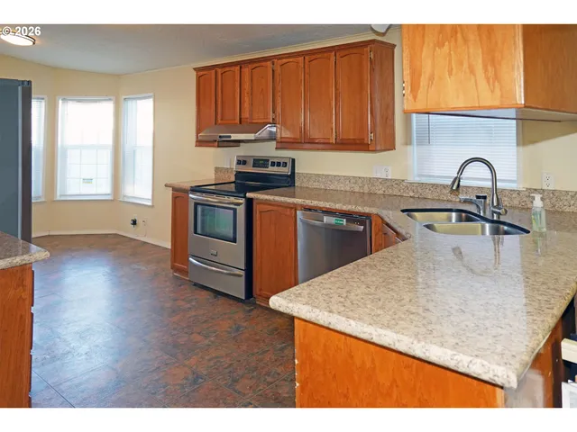 a kitchen with stainless steel appliances granite countertop a sink stove and microwave