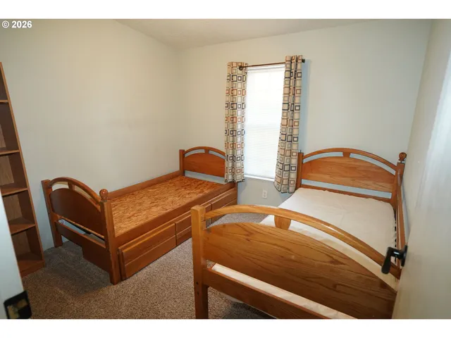 a bedroom with two beds and a window