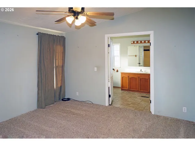 a view of an empty room and kitchen view