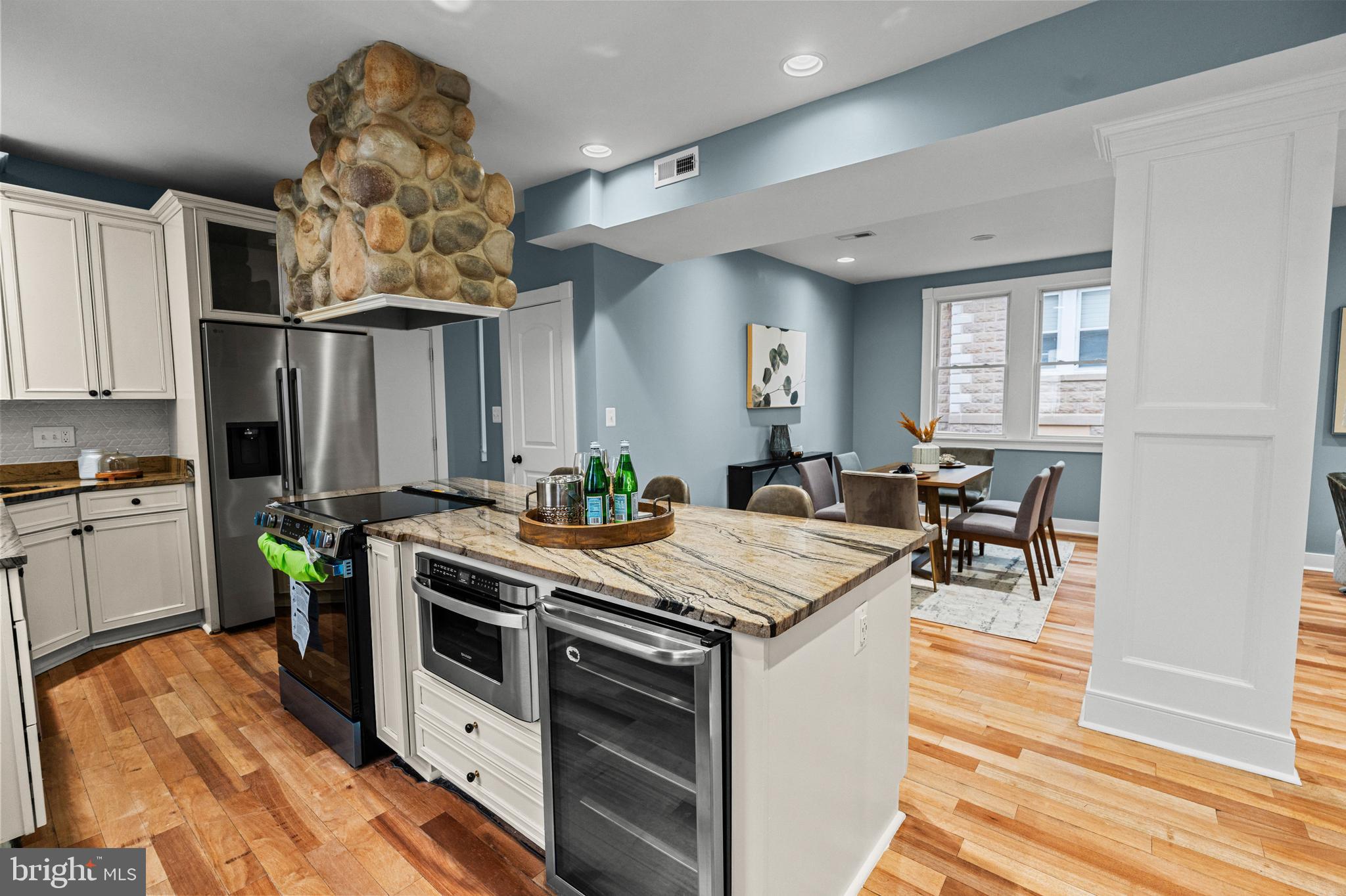 4604 Moravia Road Baltimore, MD 21206 - Photo 5 of 50 a kitchen with stainless steel appliances a stove a sink dishwasher and white cabinets with wooden floor