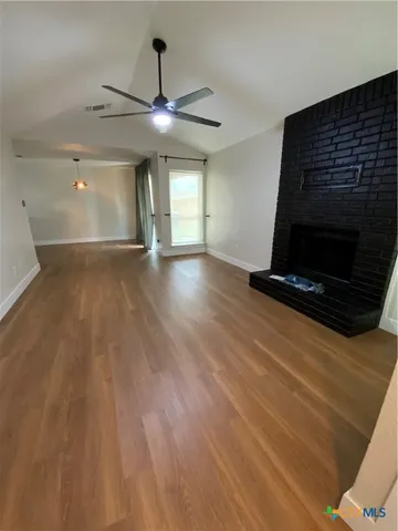 a view of a livingroom with wooden floor and a ceiling fan