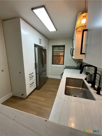 a kitchen with sink and refrigerator