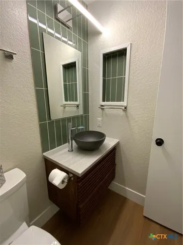 a bathroom with a sink a toilet and mirror