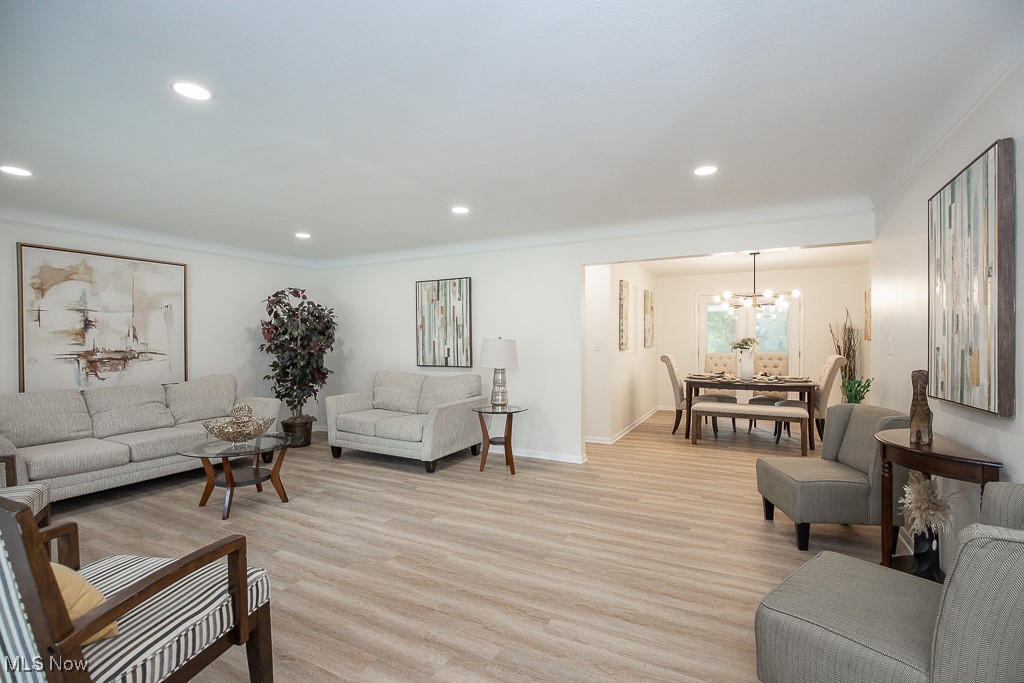 22210 Emery Road Cleveland, OH 44128 - Photo 3 of 32 Living area featuring recessed lighting, light lvt flooring, and a chandelier