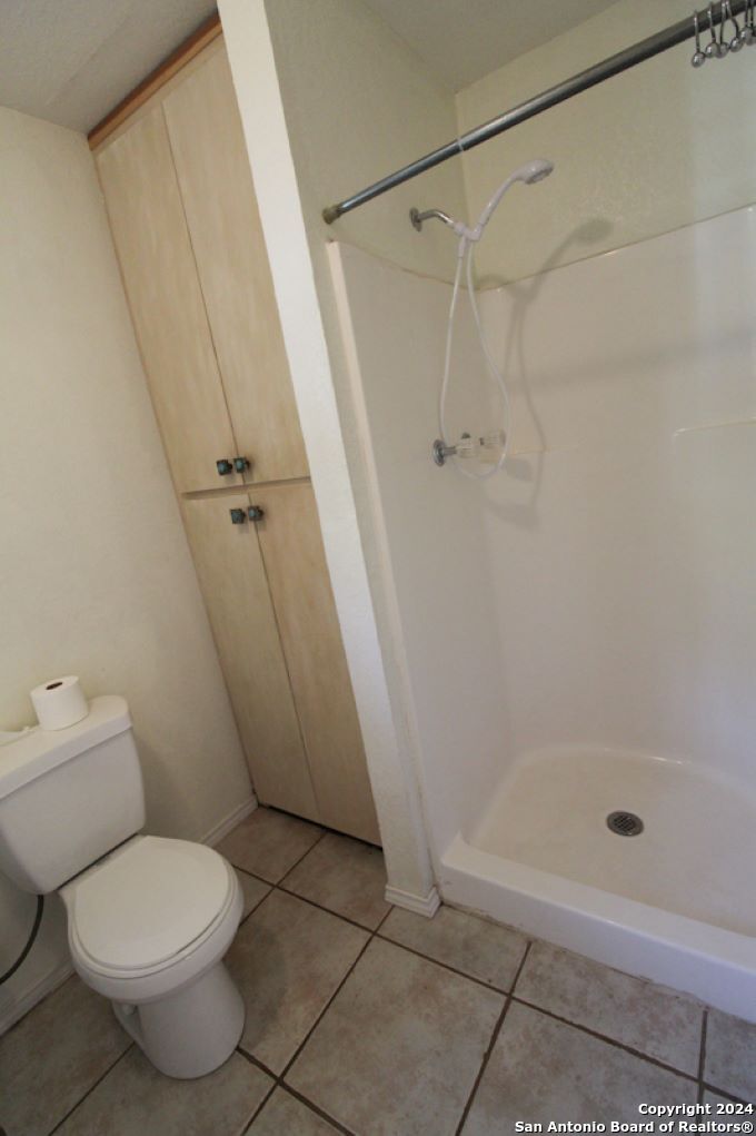 1468 Pebble Beach Road Lakehills, TX 78063 - Photo 13 of 23 a bathroom with a toilet and a shower