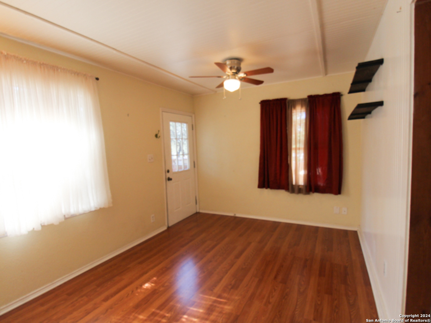 1468 Pebble Beach Road Lakehills, TX 78063 - Photo 6 of 23 a view of empty room with wooden floor and fan