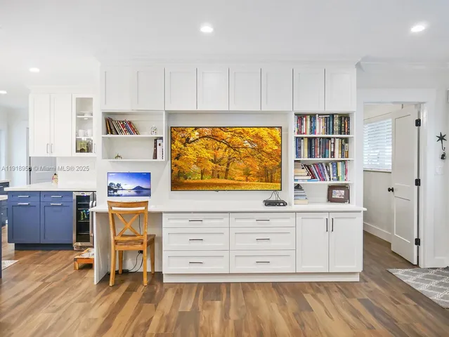 a kitchen with stainless steel appliances kitchen island wooden floors and white cabinets