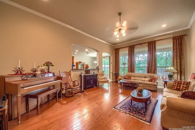 a living room with furniture a large window and a dining table