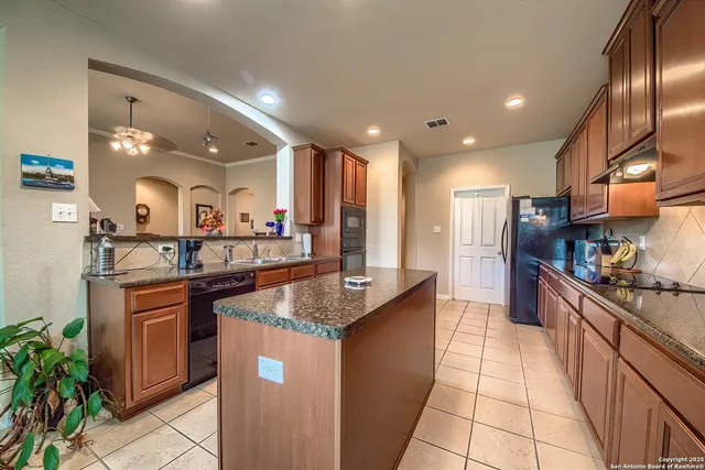 a kitchen with stainless steel appliances granite countertop a sink a stove and a refrigerator