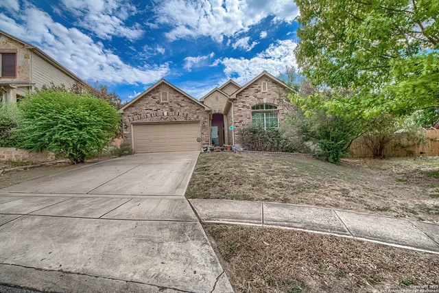a view of a house with a yard and large tree