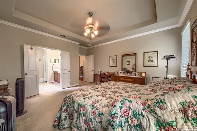 a spacious bedroom with a large bed and a chandelier