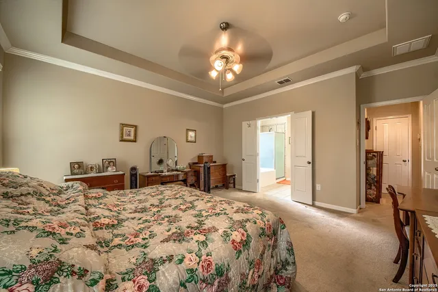 a bedroom with a large bed and a chandelier