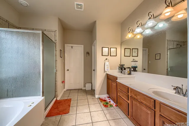 a spacious bathroom with a bathtub sink and mirror