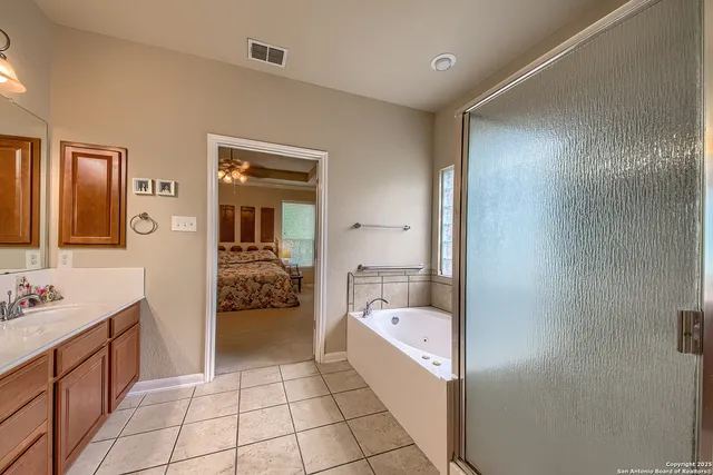 a en suite bathroom with a granite countertop sink and a large mirror
