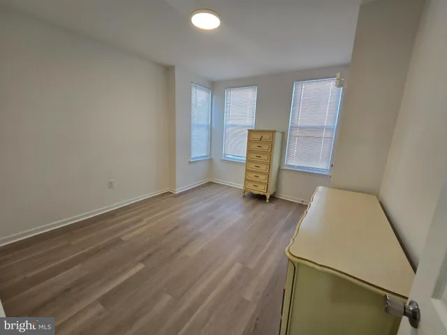 a view of room with wooden floor and electronic appliances