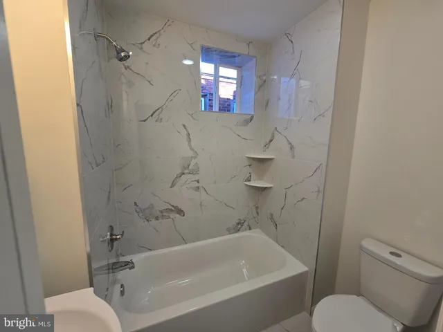 a bathroom with a toilet bathtub and shower