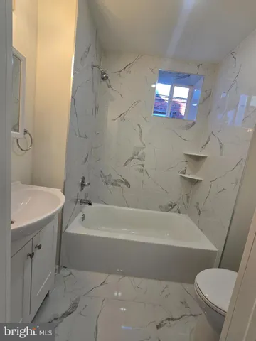 a bath room with a toilet a bath tub and a shower