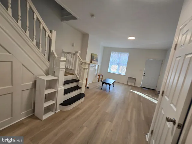 a view of a livingroom with wooden floor and staircase