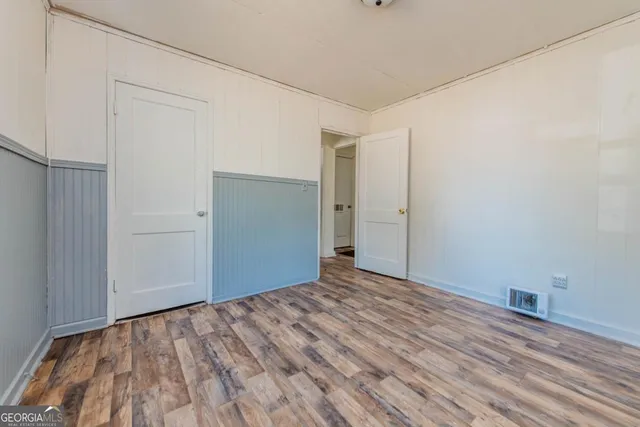 a view of empty room with wooden floor