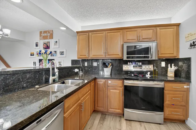 a kitchen with stainless steel appliances granite countertop a sink stove microwave and cabinets
