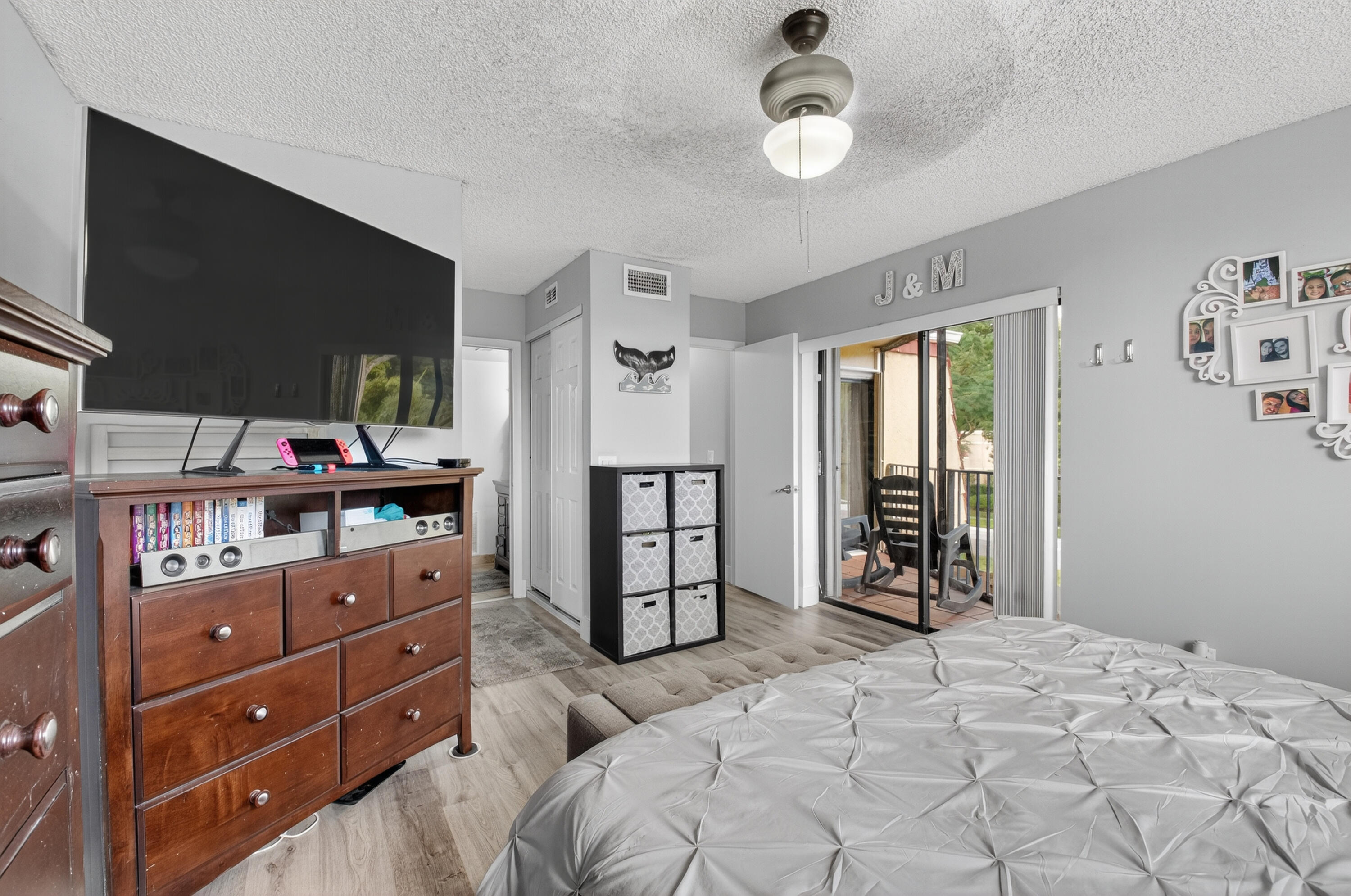 8200 Thames Boulevard, Unit C Boca Raton, FL 33433 - Photo 12 of 45 a bedroom with a dresser and a chandelier