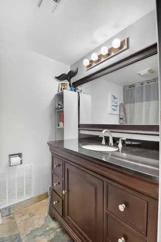 a bathroom with a granite countertop sink toilet and a mirror