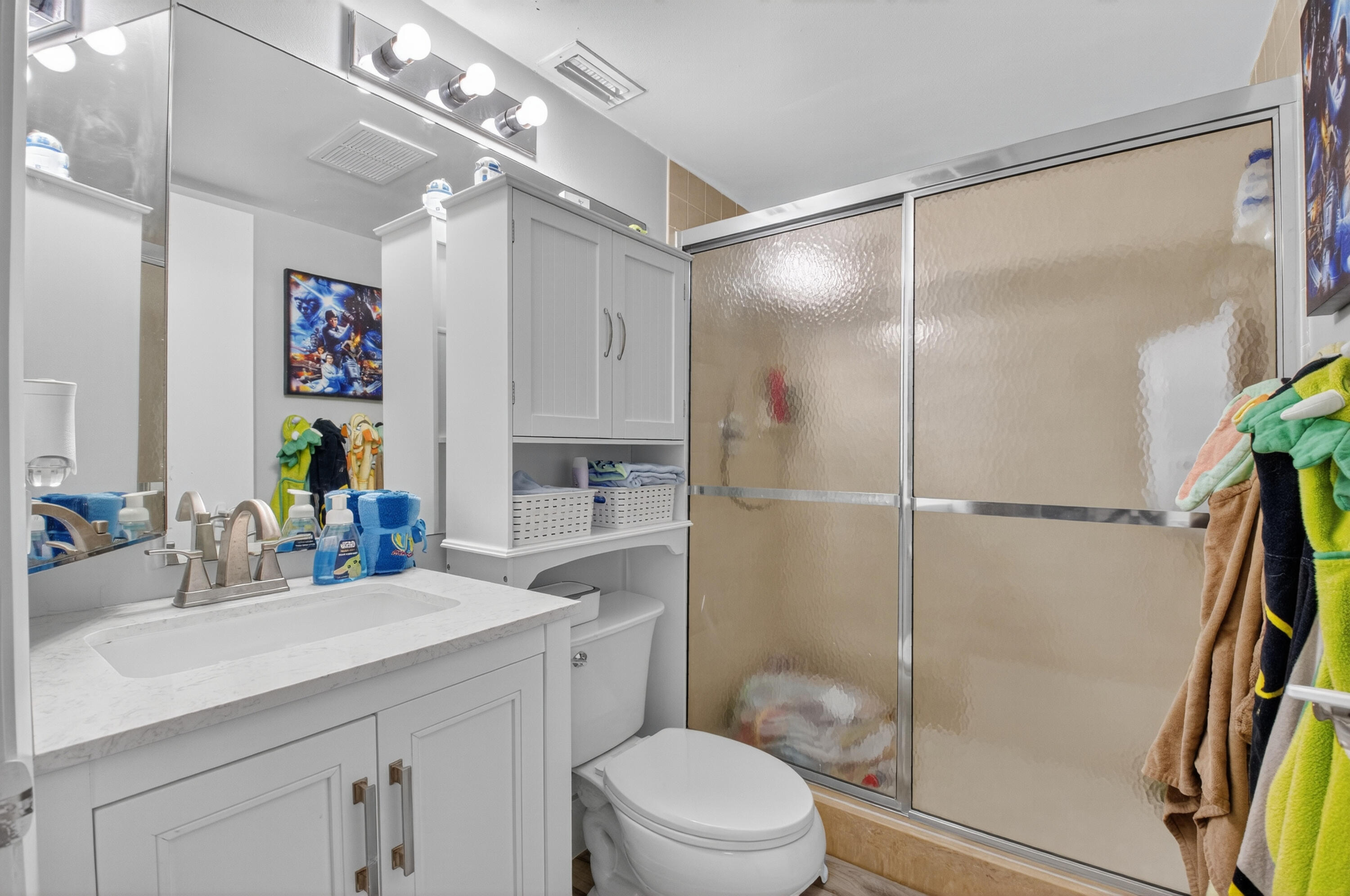 8200 Thames Boulevard, Unit C Boca Raton, FL 33433 - Photo 18 of 45 a bathroom with a sink a toilet a mirror a vanity and shower