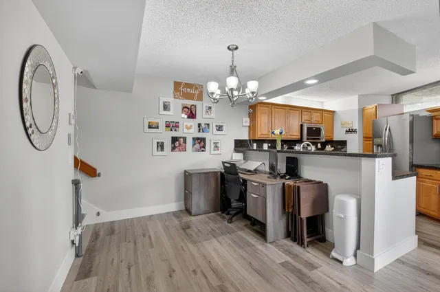 a kitchen with granite countertop a sink a counter top space cabinets stainless steel appliances and a window
