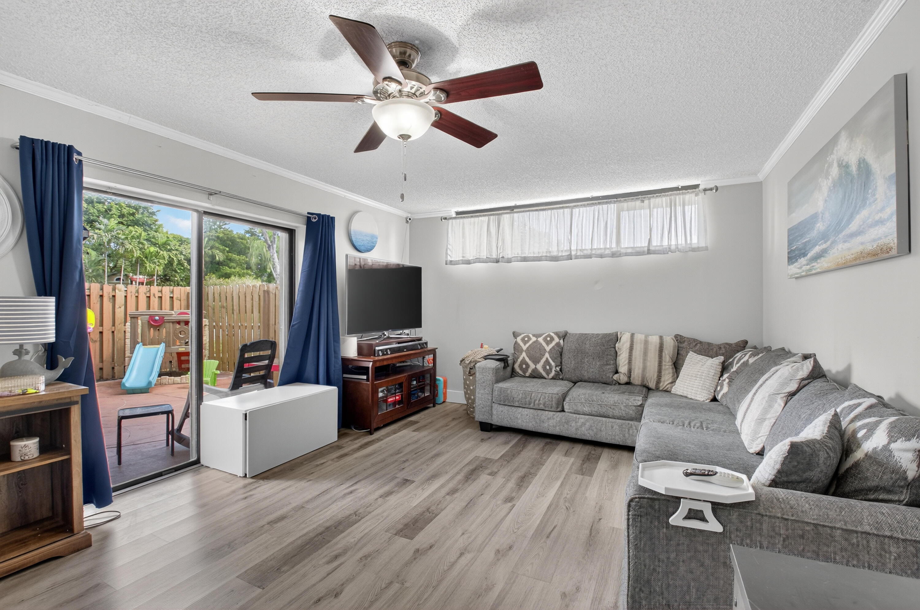 8200 Thames Boulevard, Unit C Boca Raton, FL 33433 - Photo 9 of 45 a living room with furniture flat screen tv and a large window