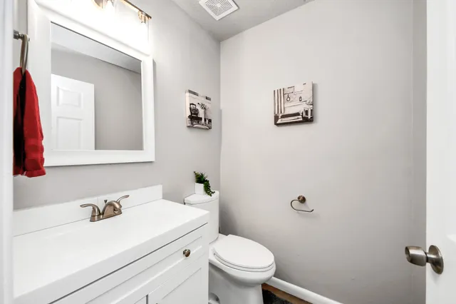 a bathroom with a sink vanity mirror and toilet