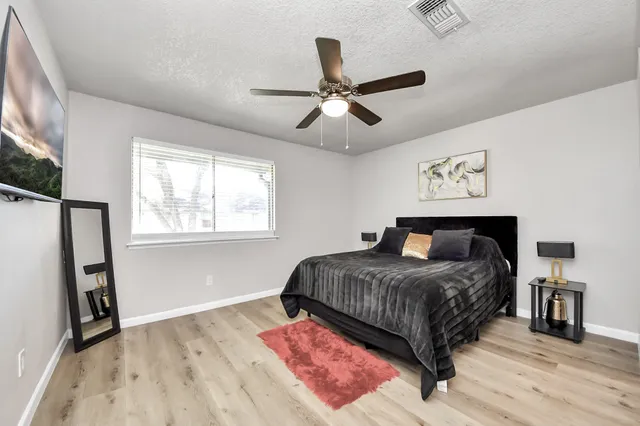 a bedroom with a bed and wooden floor