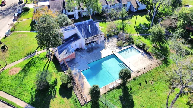 an aerial view of a house with a yard and trees