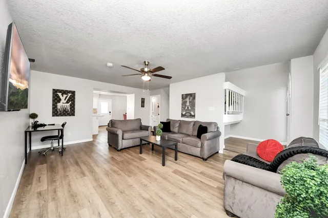 a living room with furniture and a wooden floor