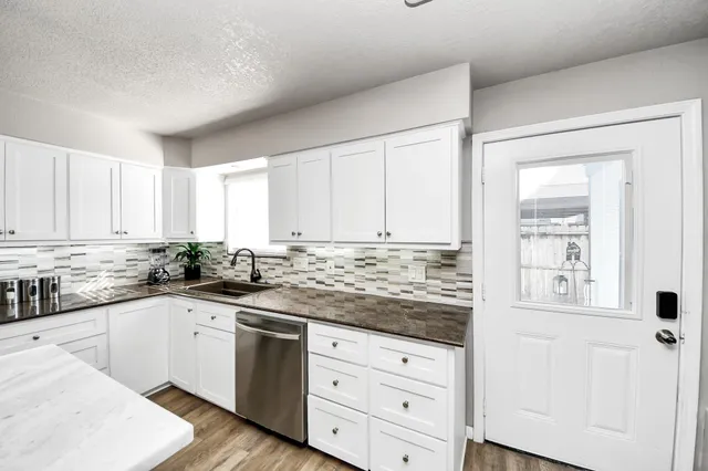 a kitchen with granite countertop white cabinets and white appliances