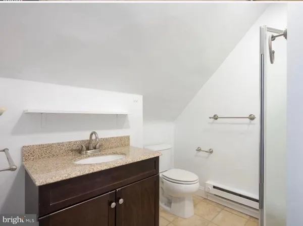 a bathroom with a granite countertop sink a toilet and a mirror