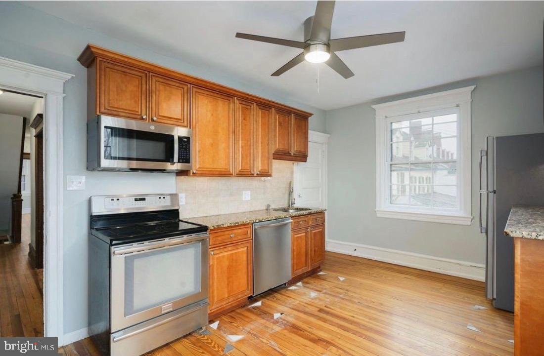 239 Kings Highway East, Unit B Haddonfield, NJ 08033 - Photo 7 of 14 a kitchen with stainless steel appliances granite countertop a stove top oven a sink dishwasher and white cabinets with wooden floor