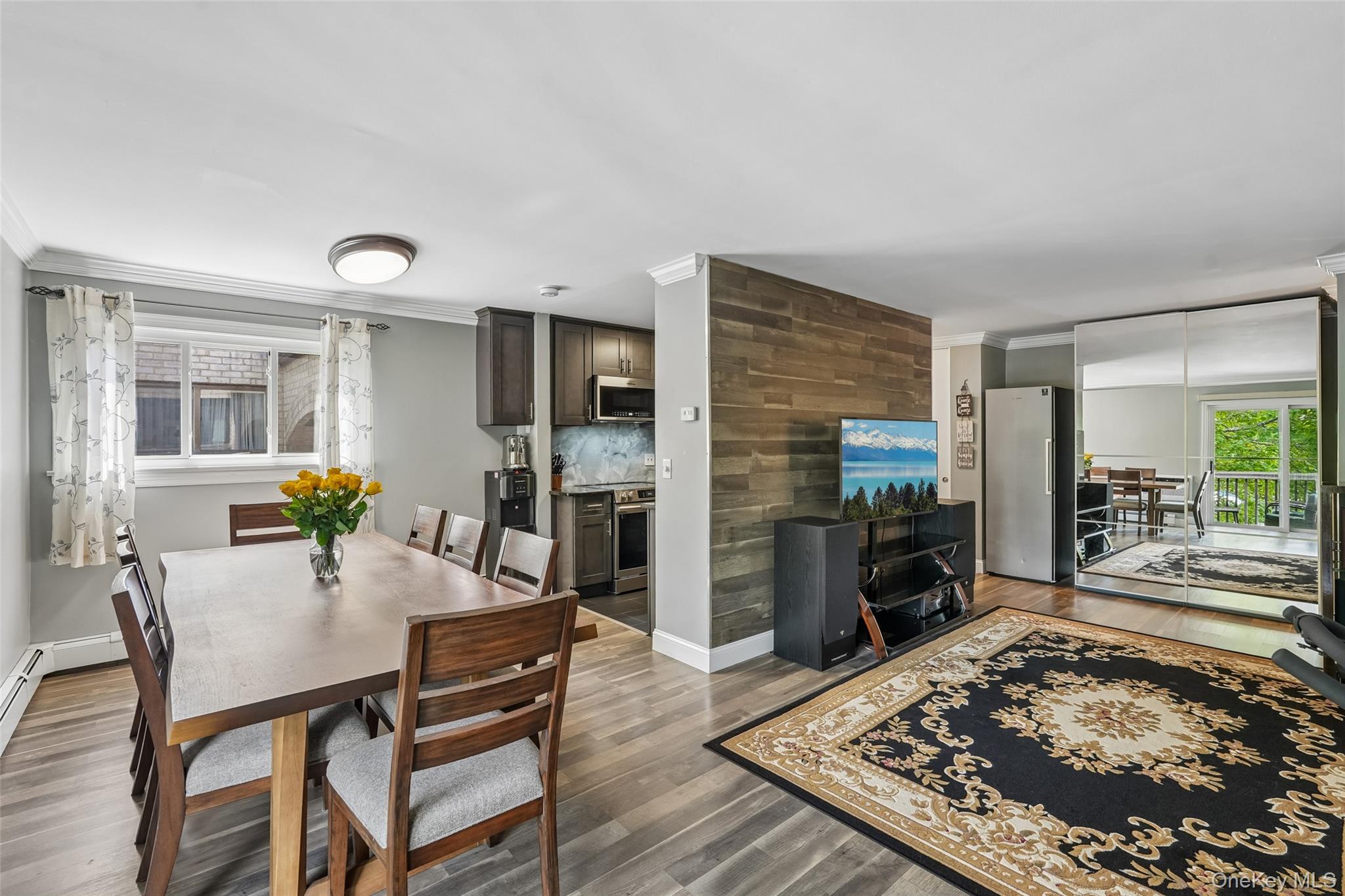 2 Secora Road, Unit C5 Monsey, NY 10952 - Photo 11 of 32 Open-concept living space with wood-finish flooring, a dining area, and a kitchen featuring dark wood cabinetry