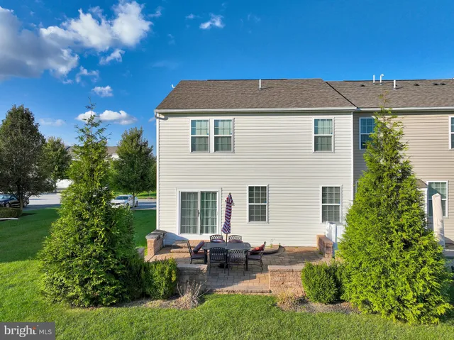a view of a white house next to a yard