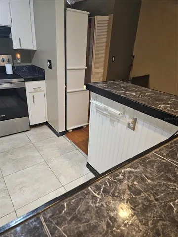 a kitchen with granite countertop cabinets and black appliances