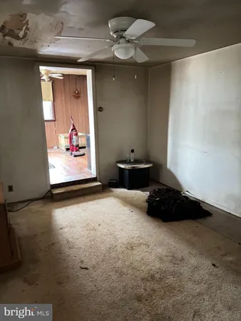a view of a garage with furniture and a ceiling fan