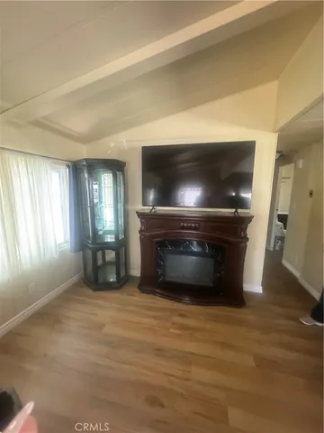 a view of empty room with a fireplace and wooden floor