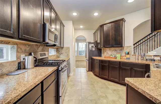 a large kitchen with stainless steel appliances granite countertop plenty wooden cabinets
