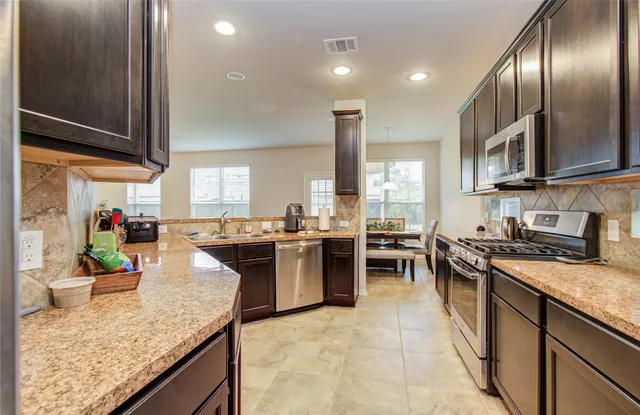 a kitchen with lots of counter top space and stainless steel appliances
