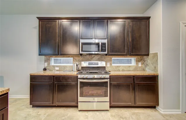 a kitchen with stainless steel appliances granite countertop a stove and a sink