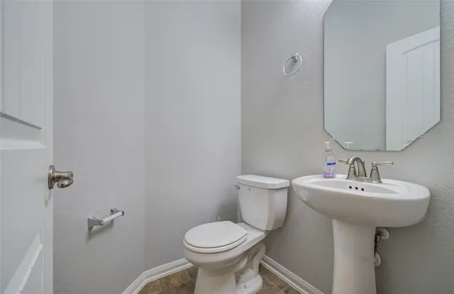 a bathroom with a sink toilet and a mirror