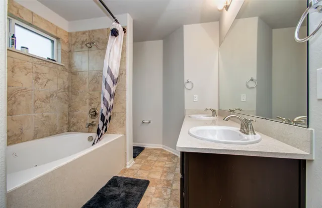 a bathroom with a sink a mirror a bathtub and shower