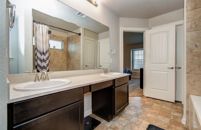 a bathroom with a double vanity sink and a mirror