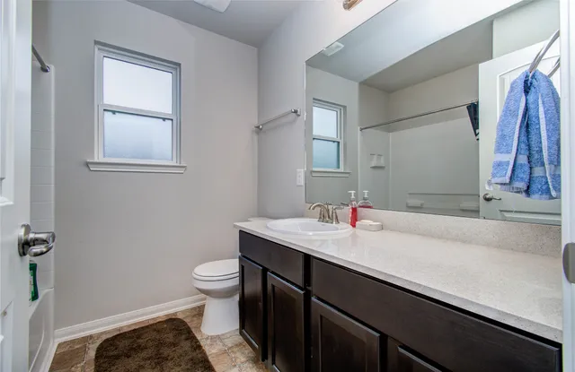 a bathroom with a sink a toilet and a mirror